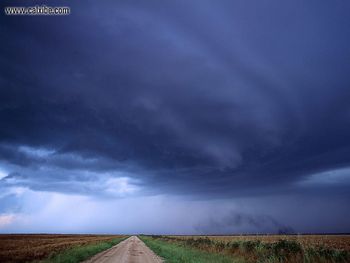 Heavy Clouds Hanging Over A Road And Field screenshot